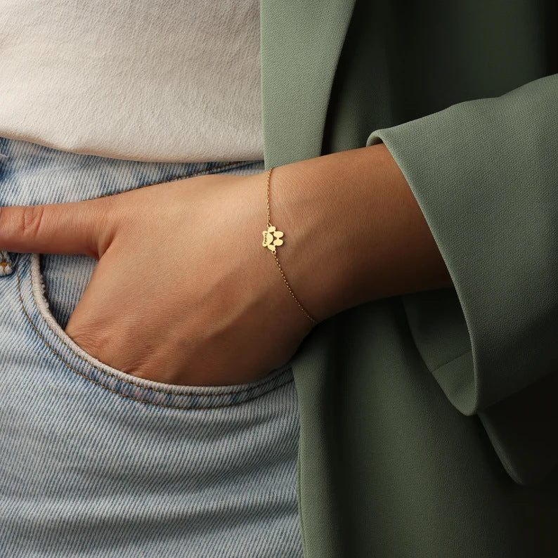 Paw print charm bracelet worn around the wrist with a small paw charm visible.