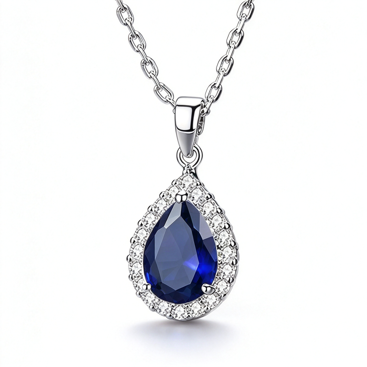Blue pear-shaped pendant necklace with a faceted centerpiece and a sparkling halo setting.