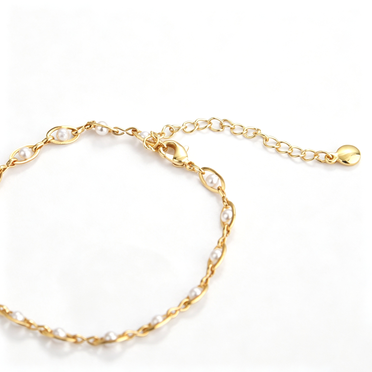 Close-up of oval bracelet links showing the white bead accents and chain detail