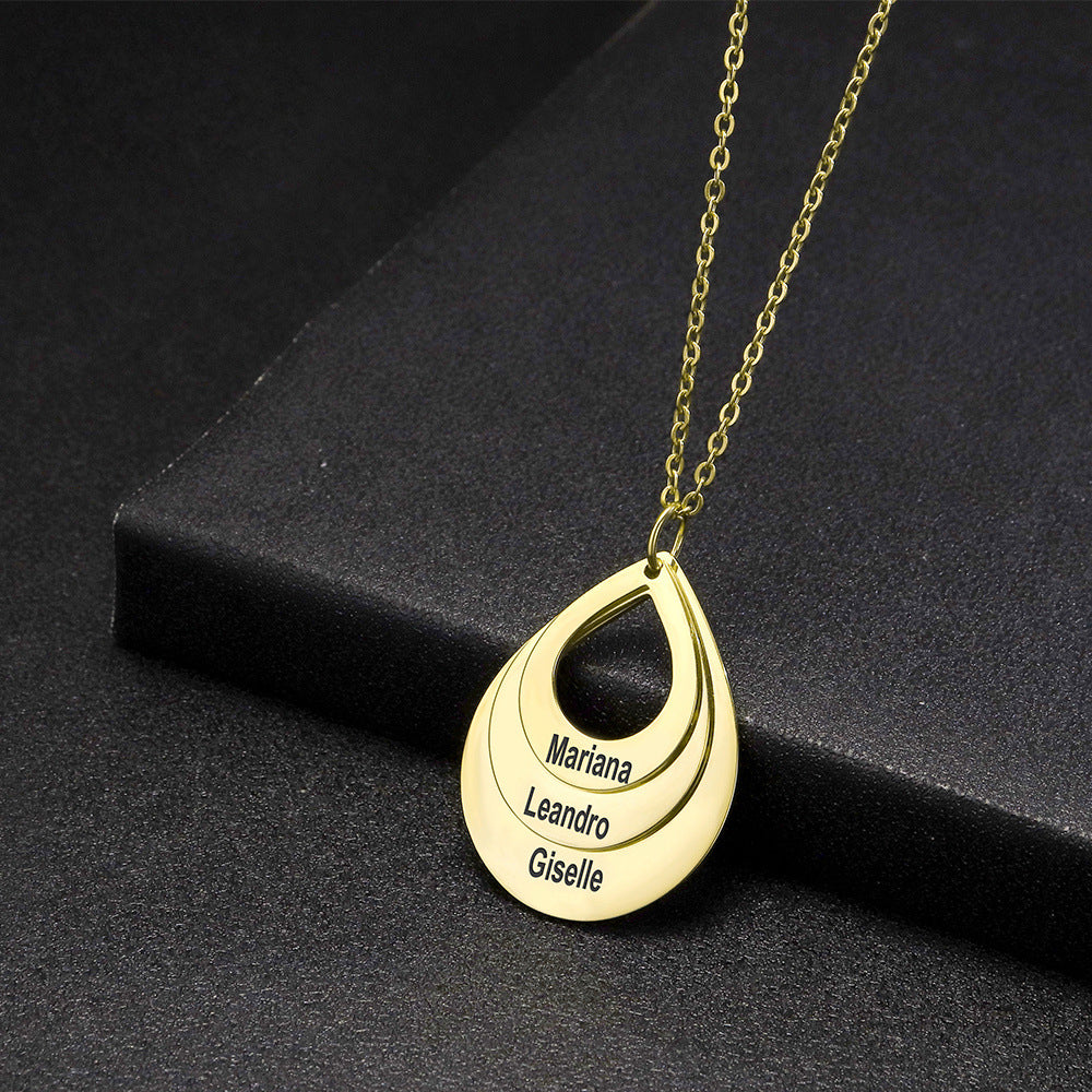 Gold-tone personalized necklace arranged at an angle on a dark textured display surface.