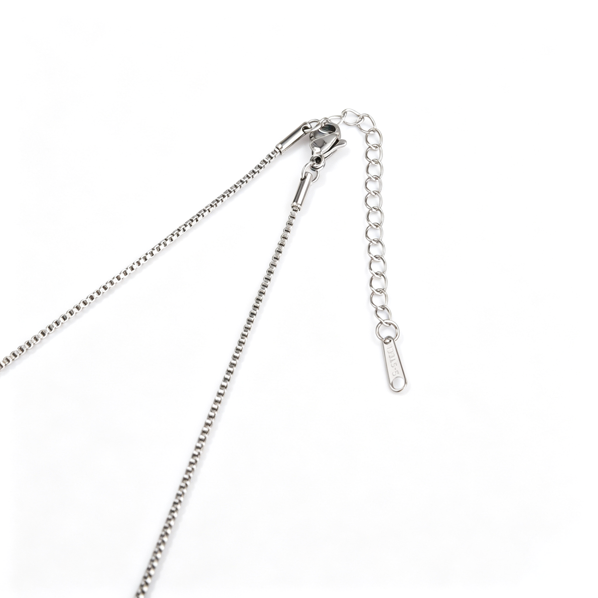 Close-up view of a silver-tone lobster clasp, extender chain, and tag on a box chain.