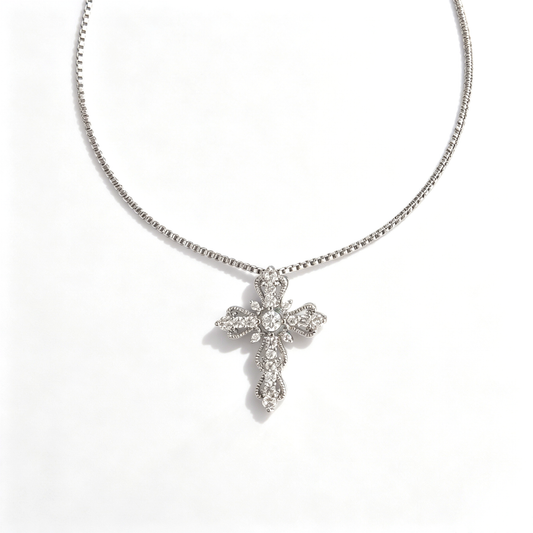 Front view of a scalloped cross pendant set with a central crystal and pavé cubic zirconia.
