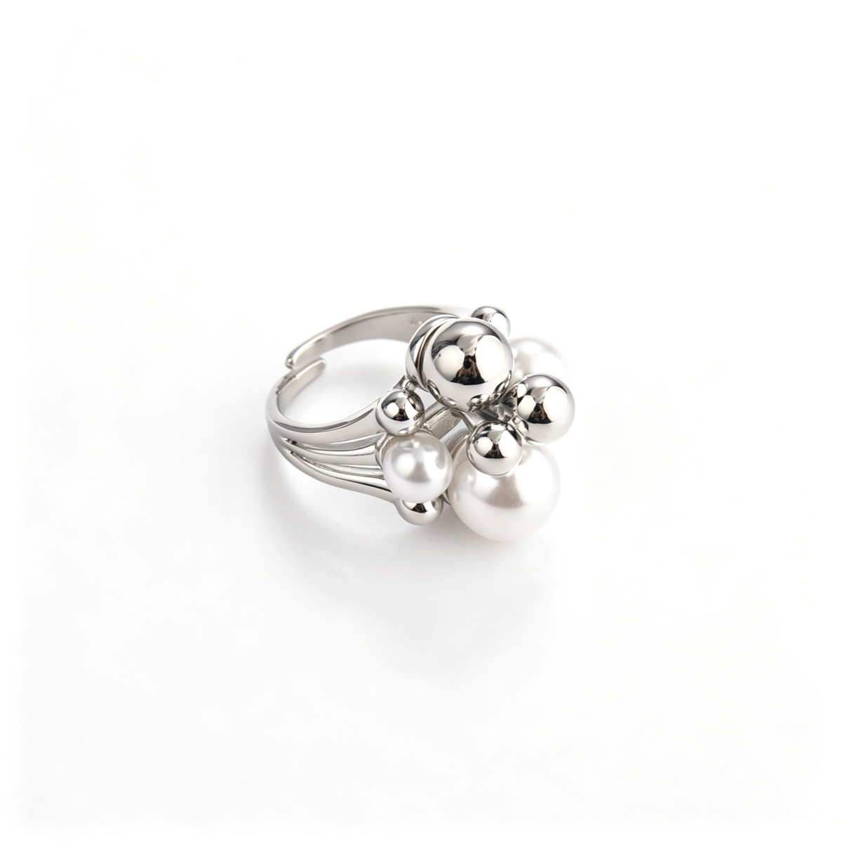 Side angled view of silver cluster ring showing pearl and metallic sphere arrangement with adjustable band.