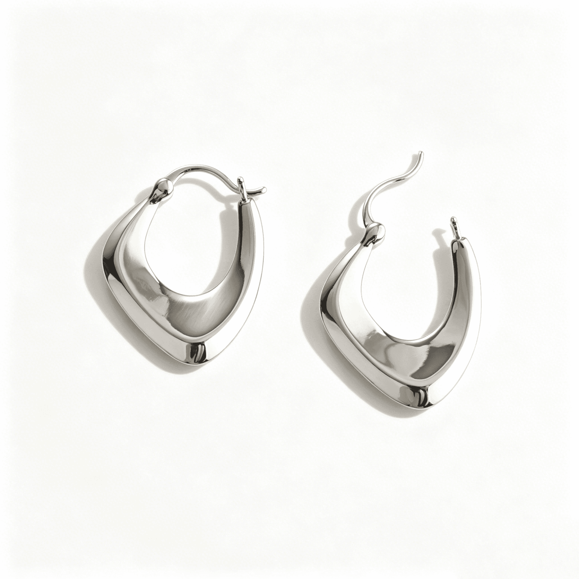 Ever P. silver hoop earrings with a modern twisted cross design in a polished silver finish.