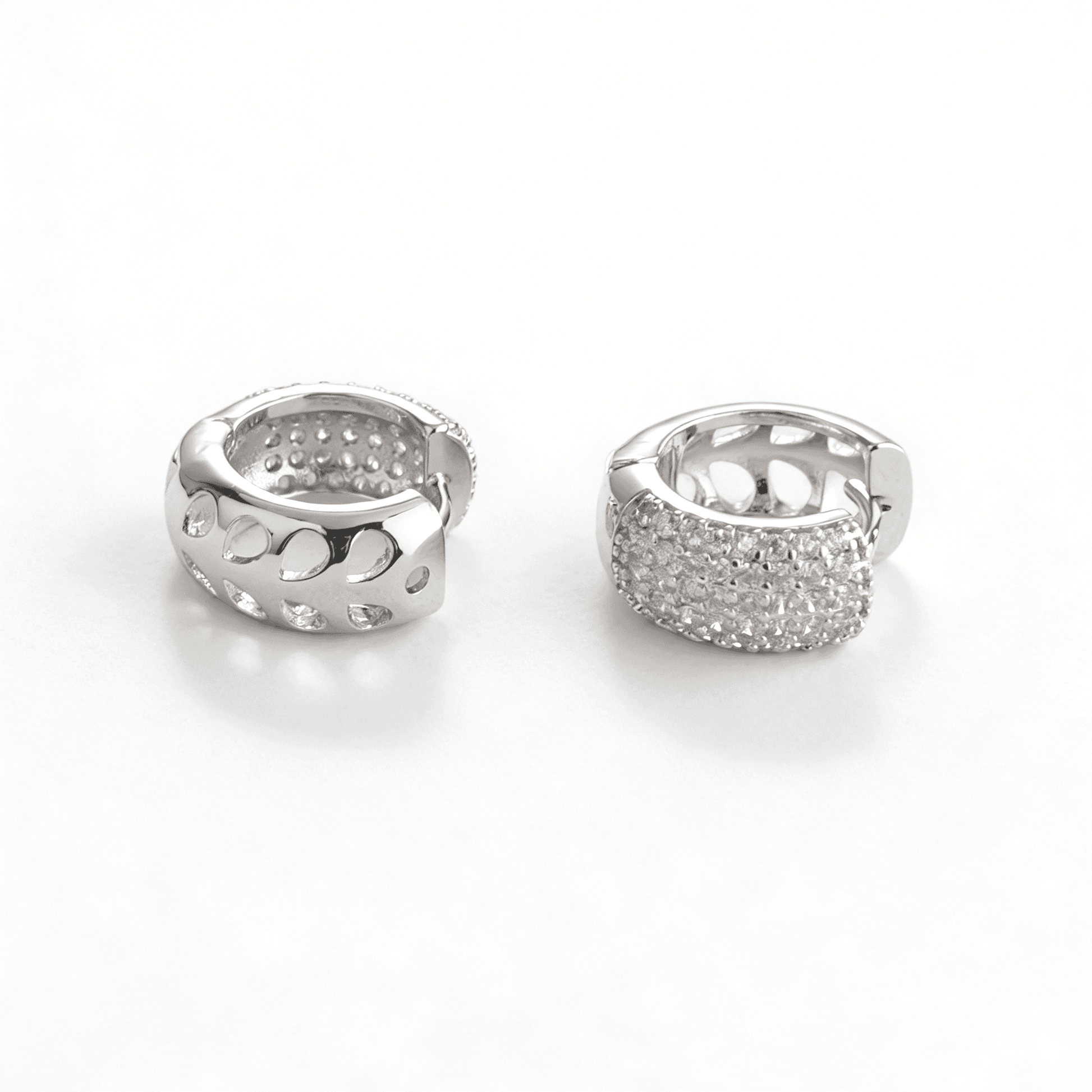 Comparison view of two silver plated hoop earrings showing the intricate geometric side and the pavé crystal front.