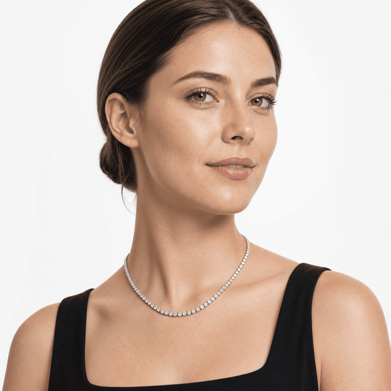 Woman wearing a silver-tone 4 mm cubic zirconia tennis necklace in a white studio