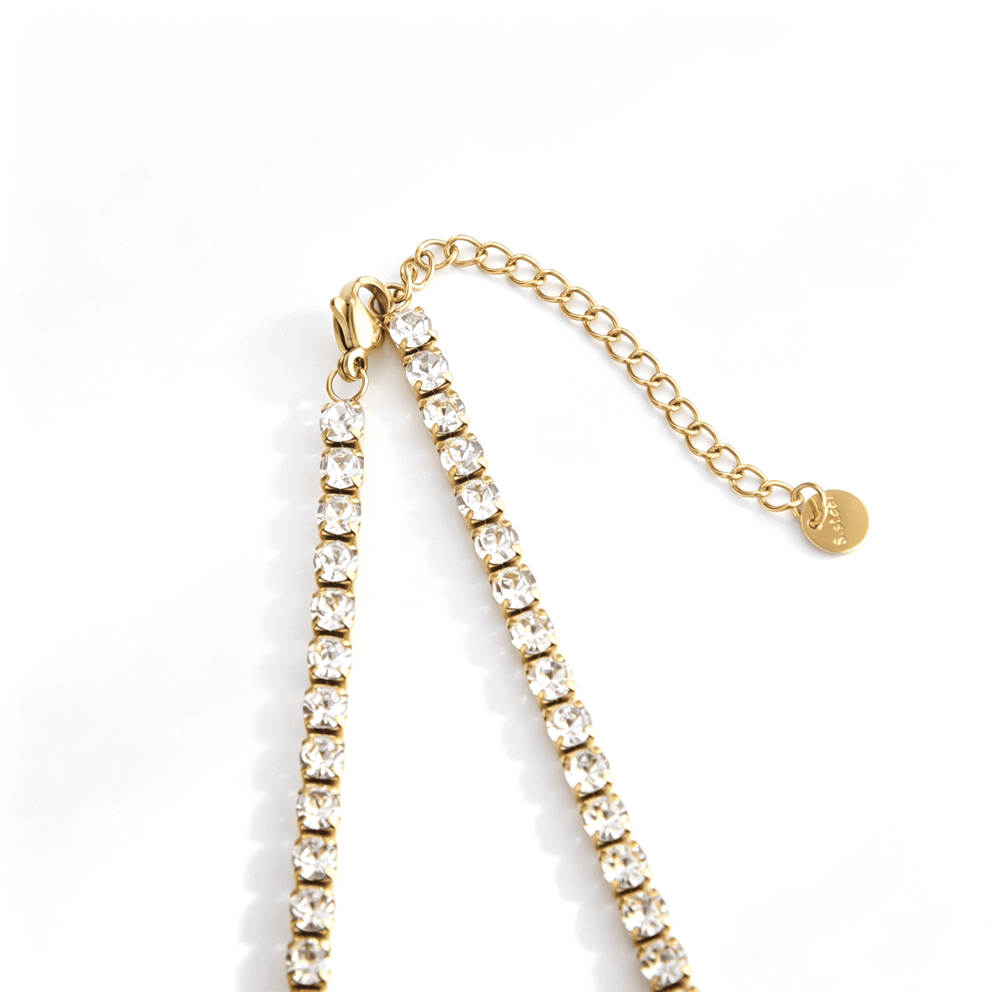 Gold-tone tennis necklace lobster clasp, extender links, and end tag