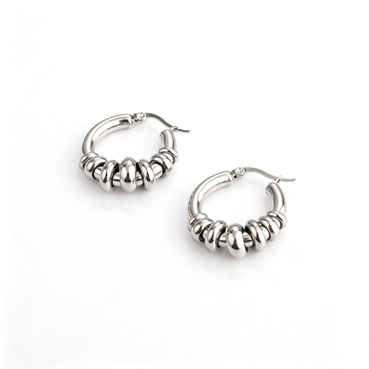 Pair of stainless steel hoop earrings featuring graduating sliding ring beads and latch back clasp.
