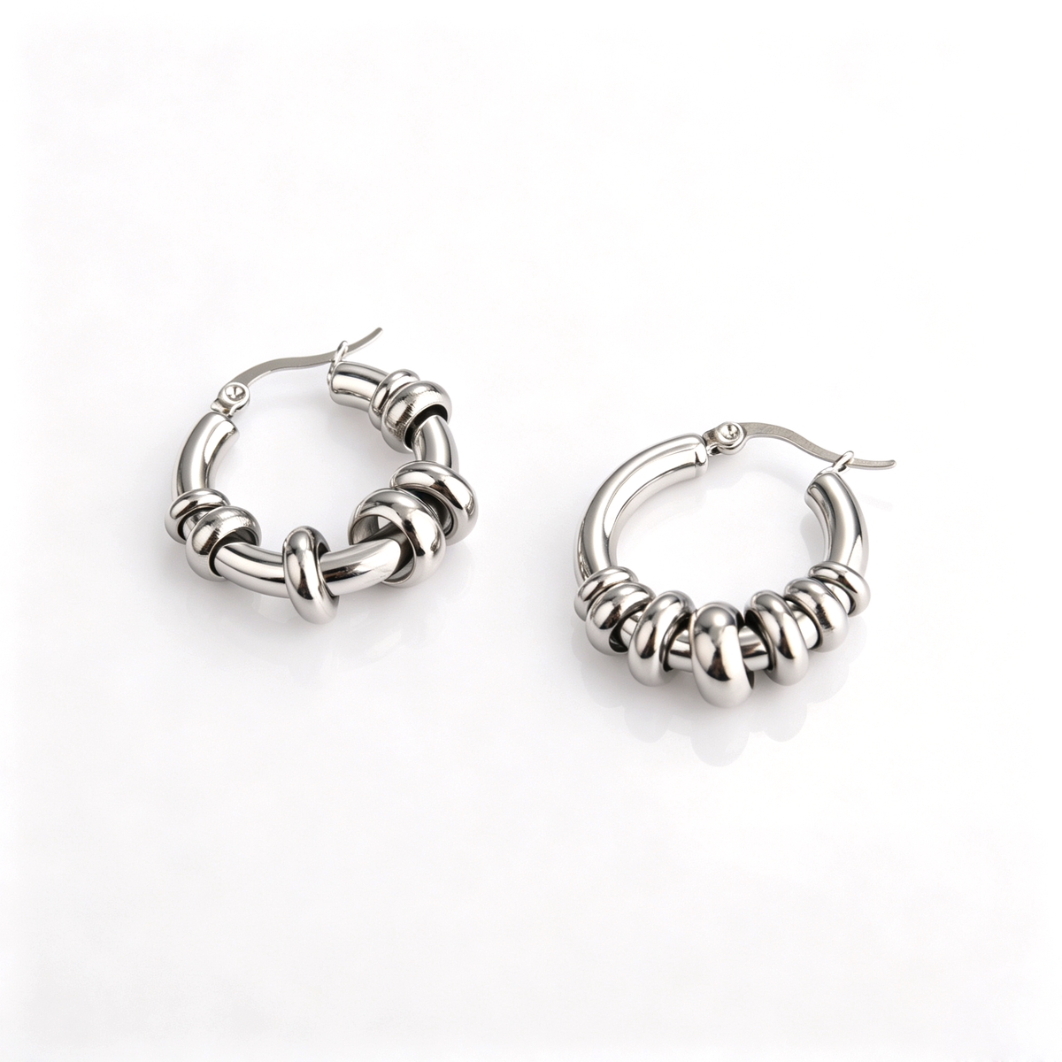 Angled view showing the loose movable ring beads sliding along the silver-tone stainless steel hoops.