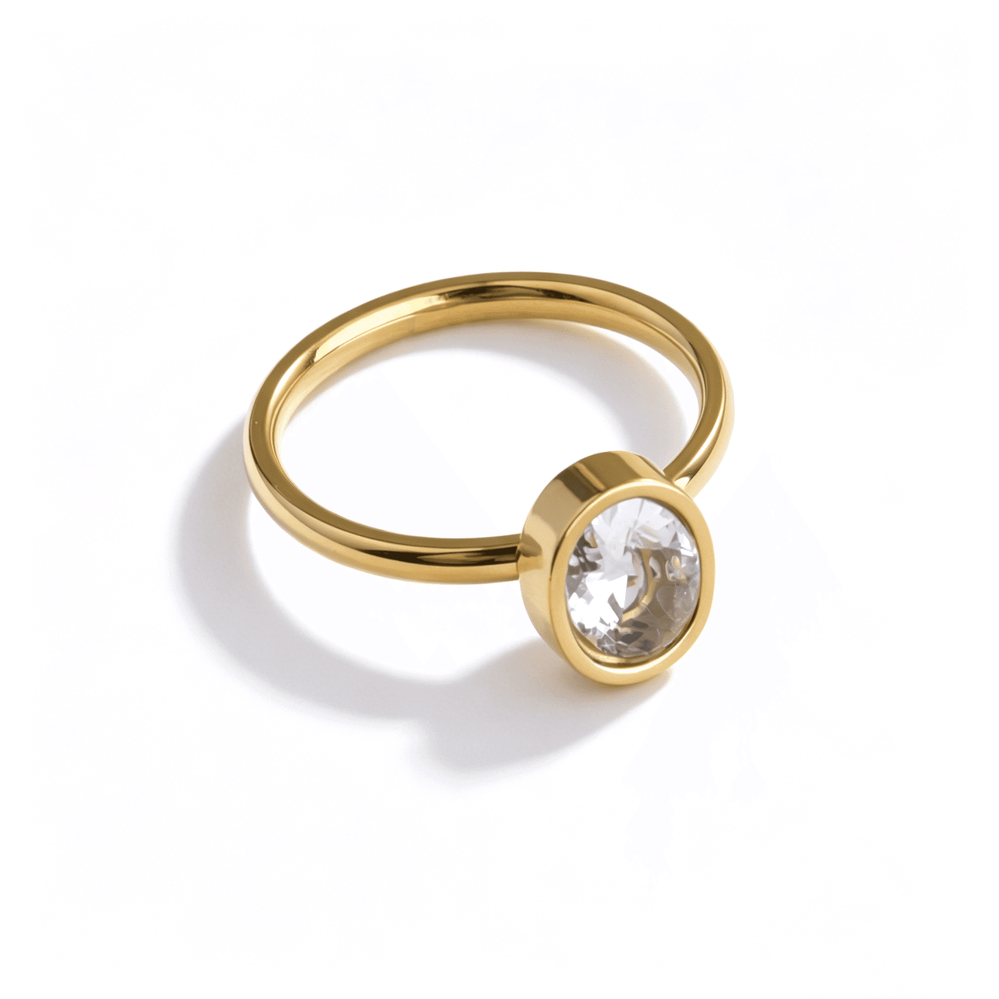 Angled view of a classic gold plated stainless steel solitaire ring with a brilliant oval zircon.