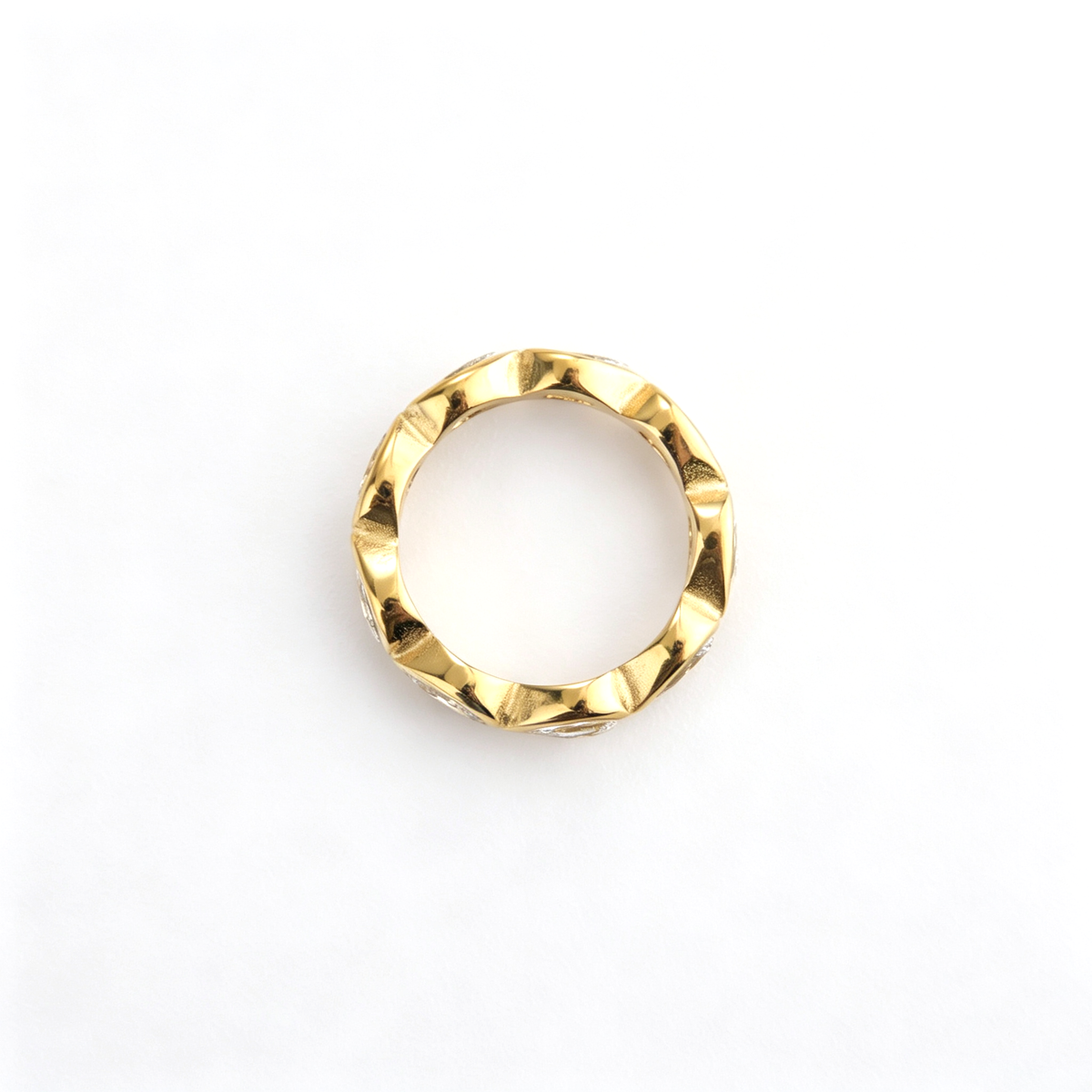 Band ring shown from a three-quarter angle with repeating teardrop-shaped decorative details