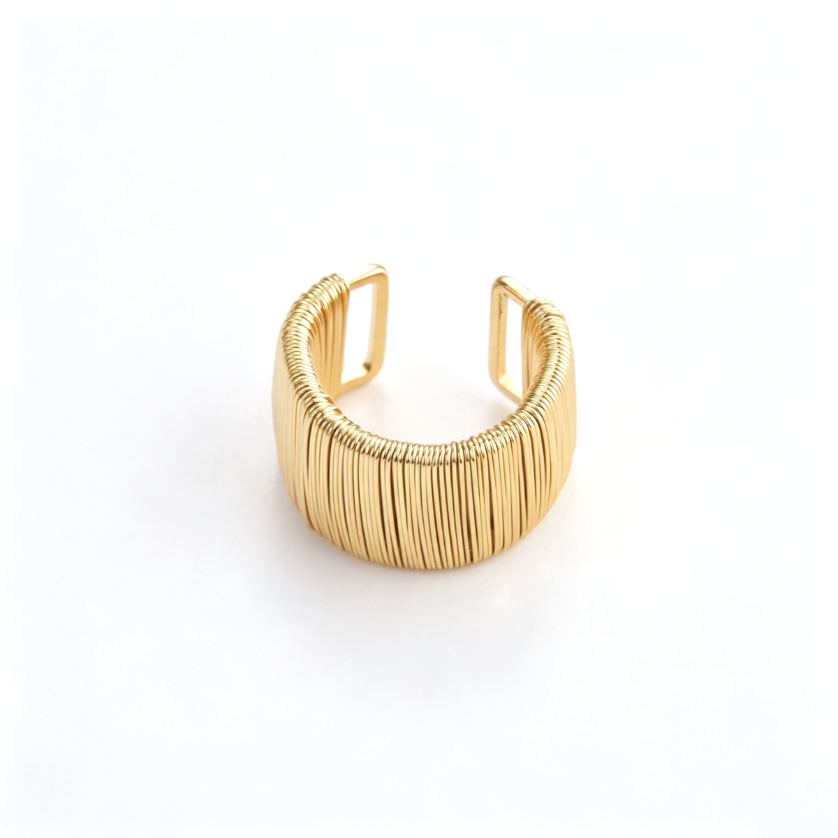Textured cuff bracelet with a wide ribbed band and open ends in an angled view