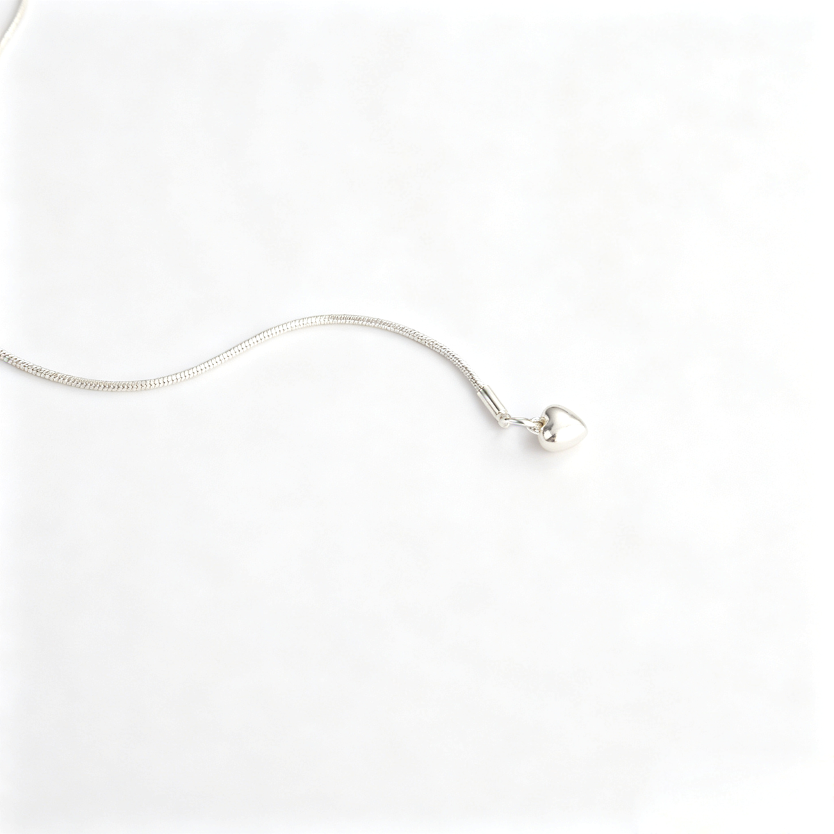 Close-up of 2.2x2.5cm handcrafted textured heart pendant with brushed brass finish