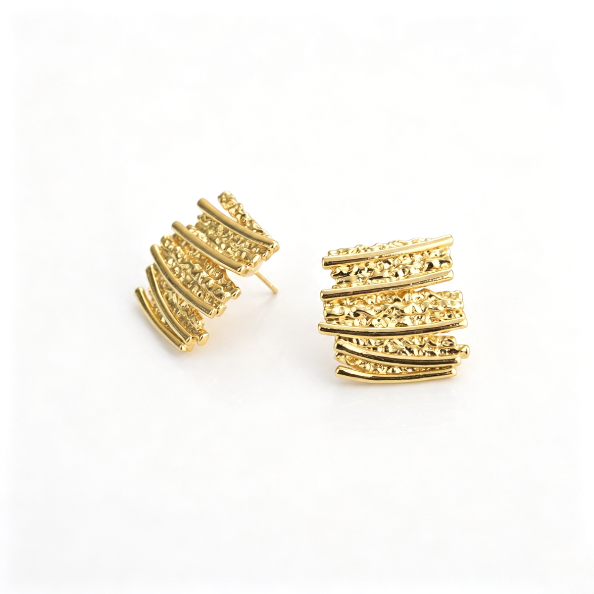 Textured stud earrings with layered curved bars and sculptural surfaces