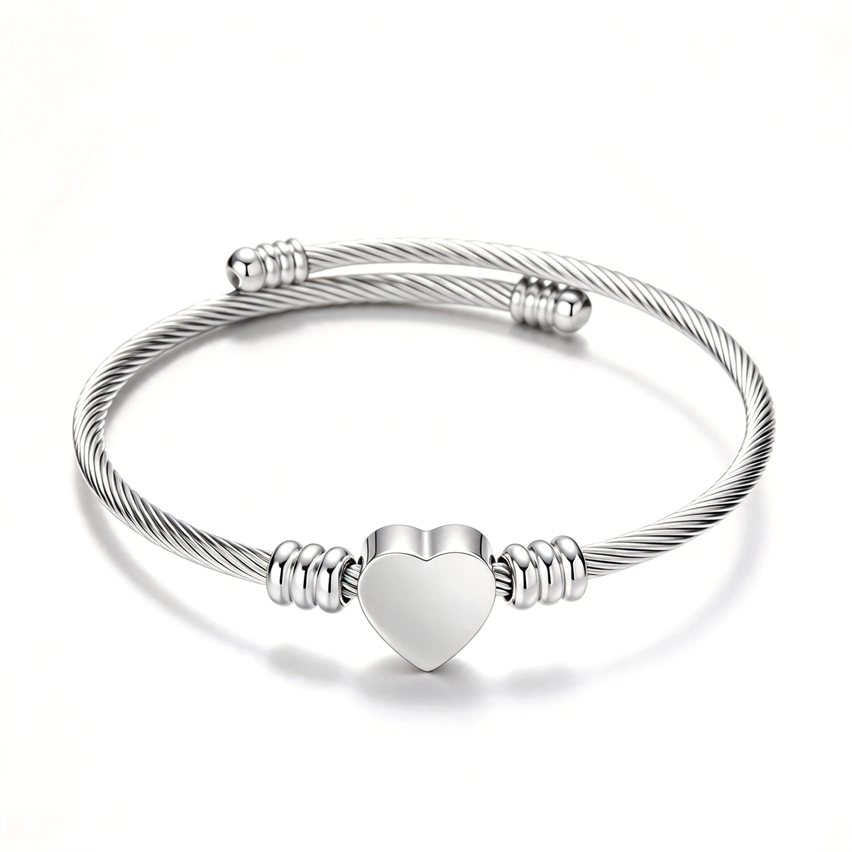Silver-tone heart cuff bracelet with a twisted band and a smooth heart centerpiece.