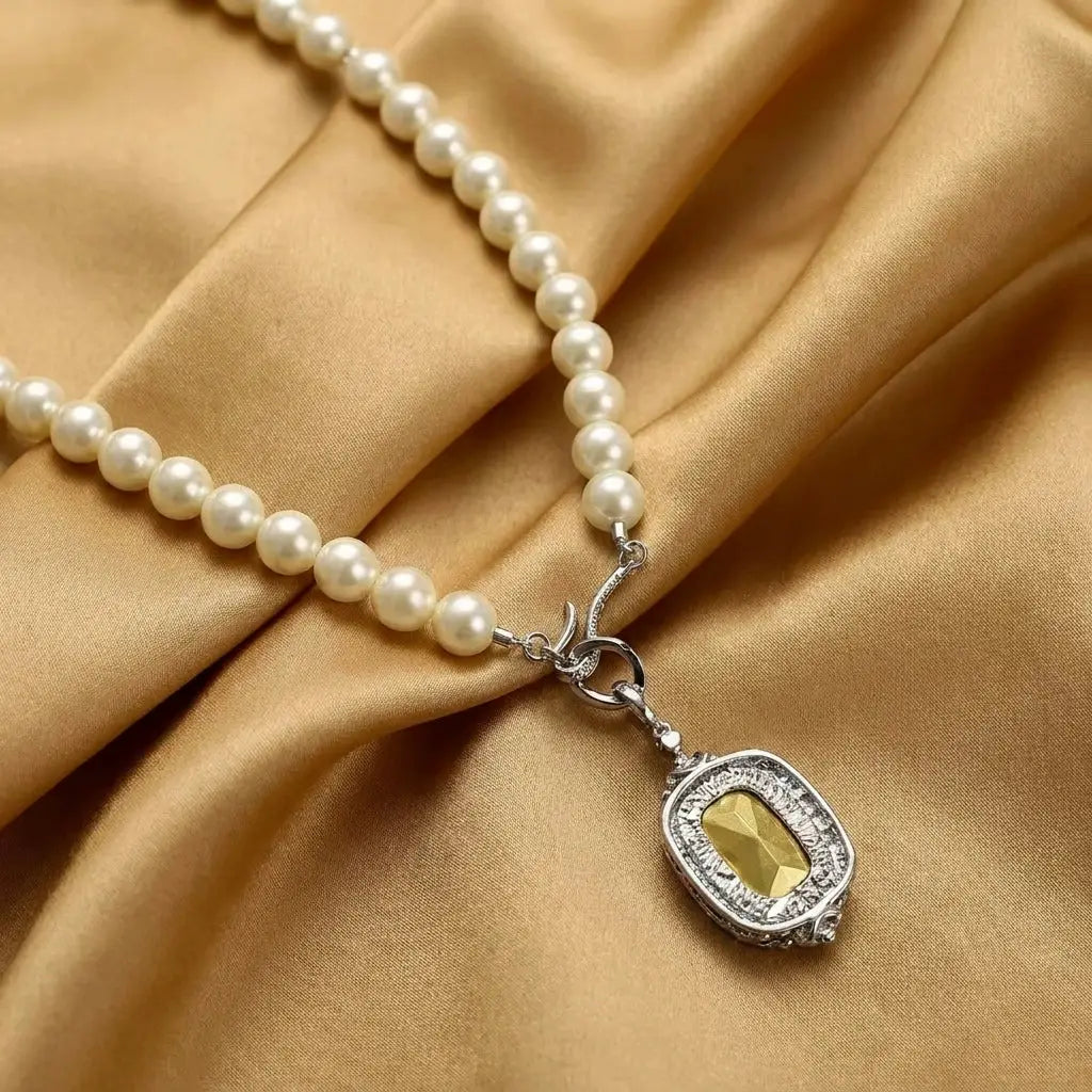 Close-up of the vintage rhinestone pearl necklace draped on gold satin silk, showcasing the detailed silver-plated copper clasp casing.