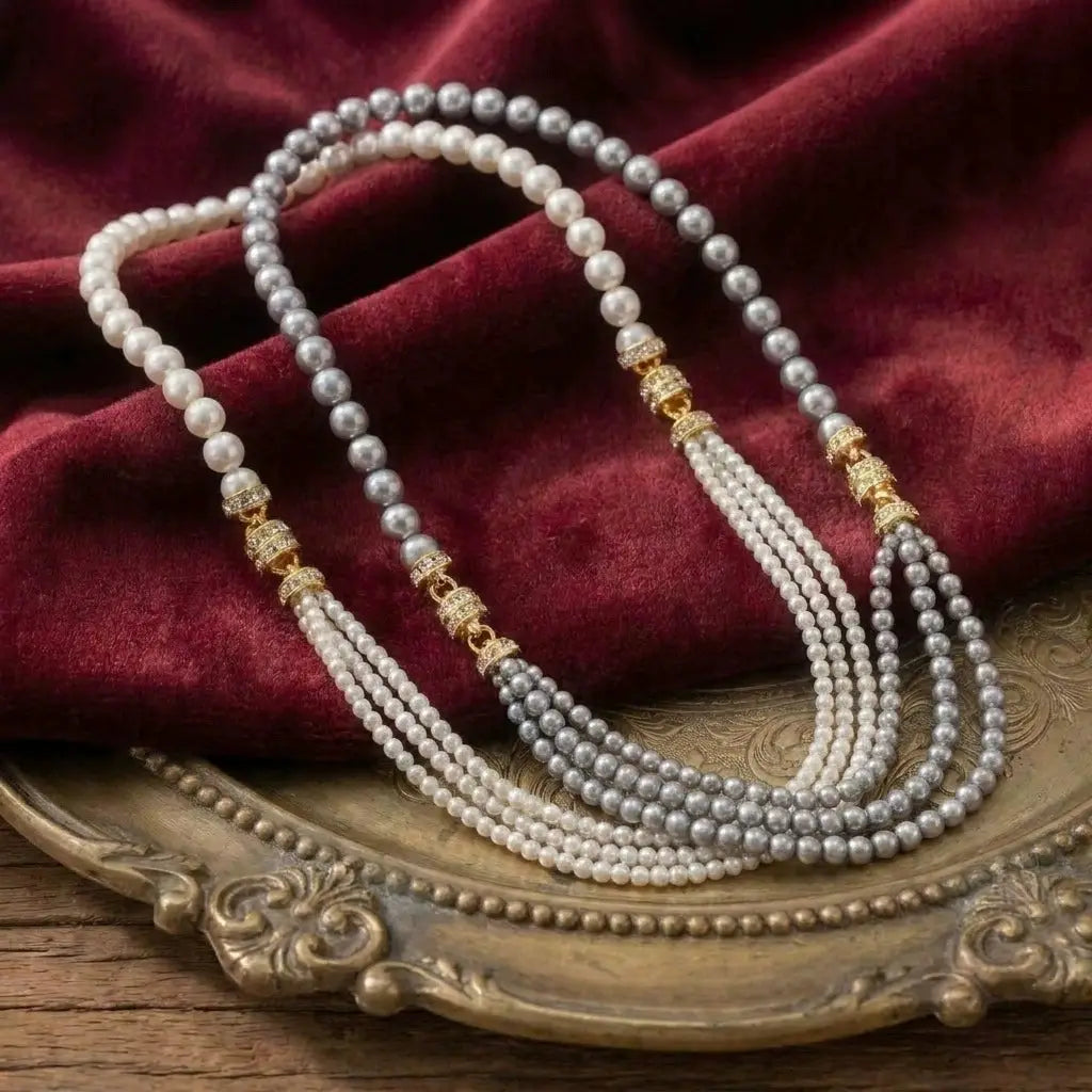Ever P. luxury styling combination featuring both white and grey French vintage multi-strand pearl necklaces layered together on a royal red velvet background.