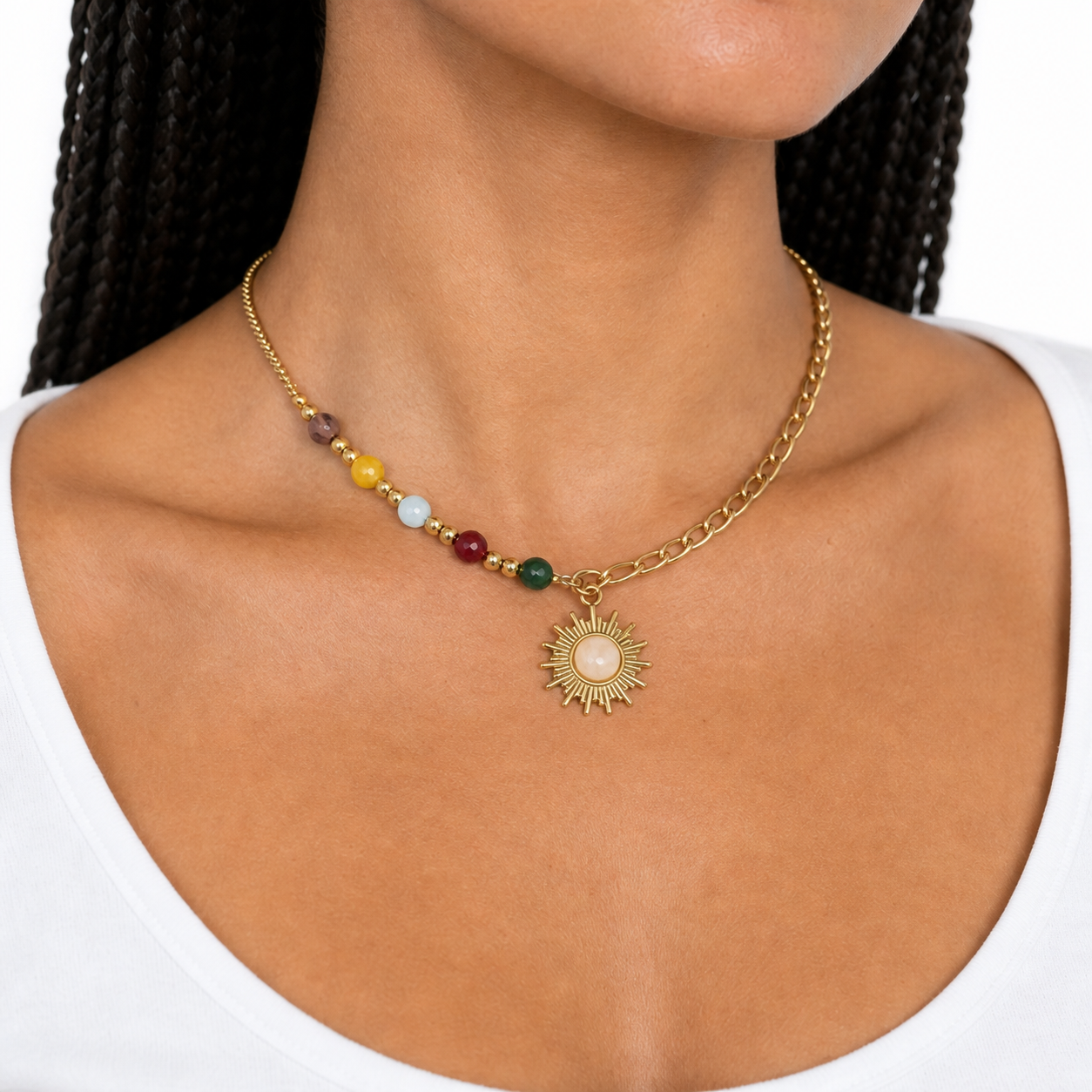 Collarbone close-up showing the colorful beads, mixed links, and small sunburst pendant.