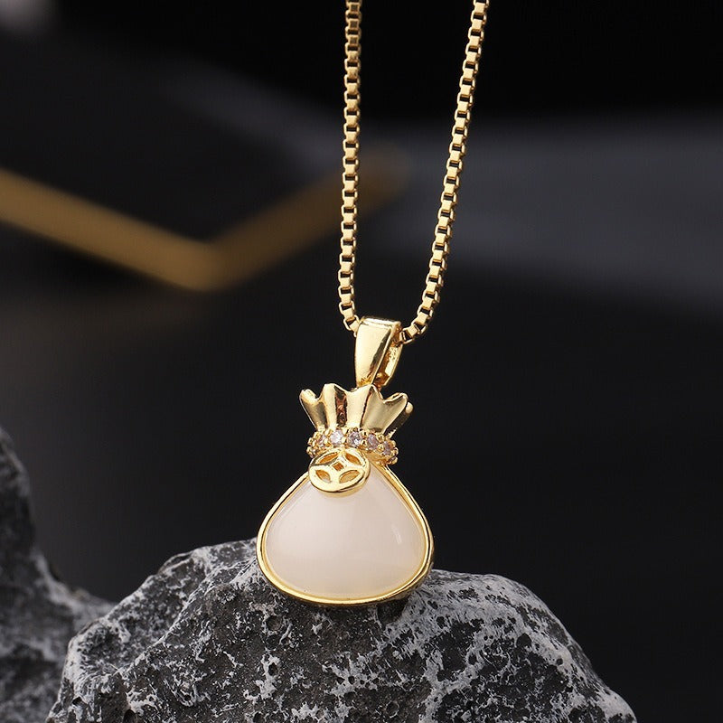 Money bag-shaped pendant necklace displayed against a dark textured background.