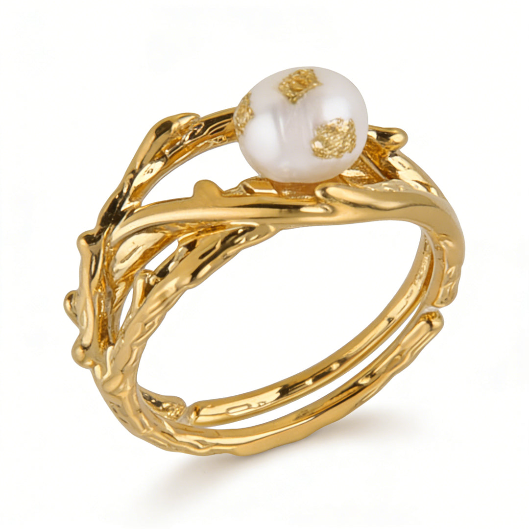 Detailed texture of wire wrapped rings featuring gold foil embellishments and a high-luster pearl.